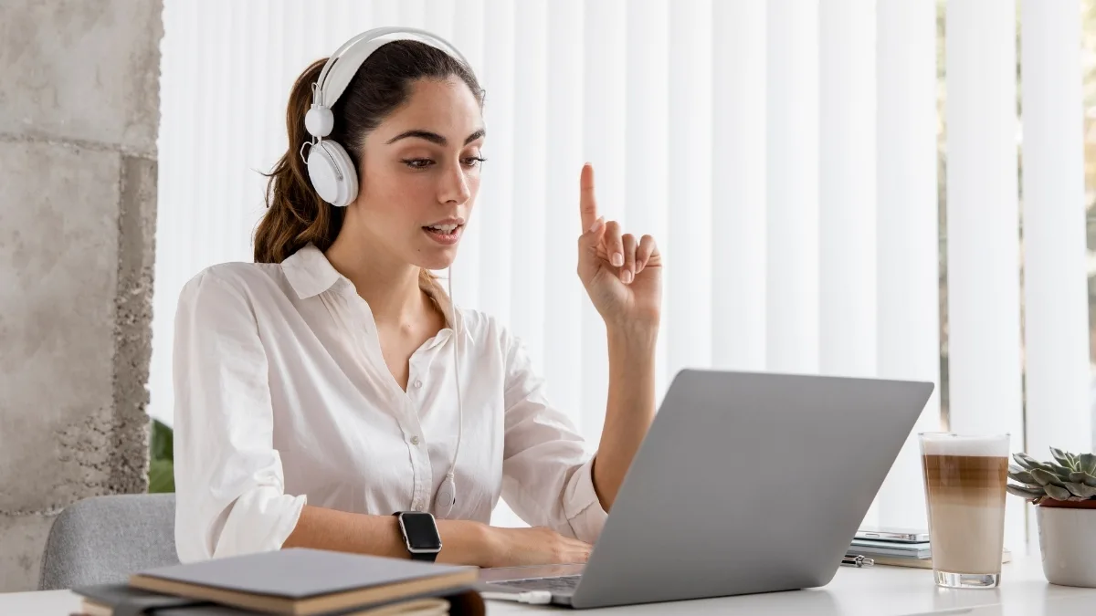Woman wearing headphones working on a laptop during a virtual assistant session.  Select 88 more words to run Humanizer.